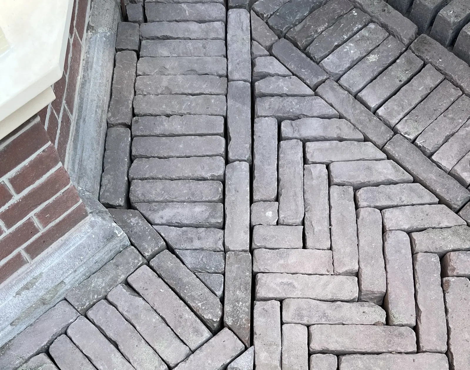 Detail visgraat klinkers rondom woning – hovenierswerk van Herfst Sierbestrating in Kinderdijk