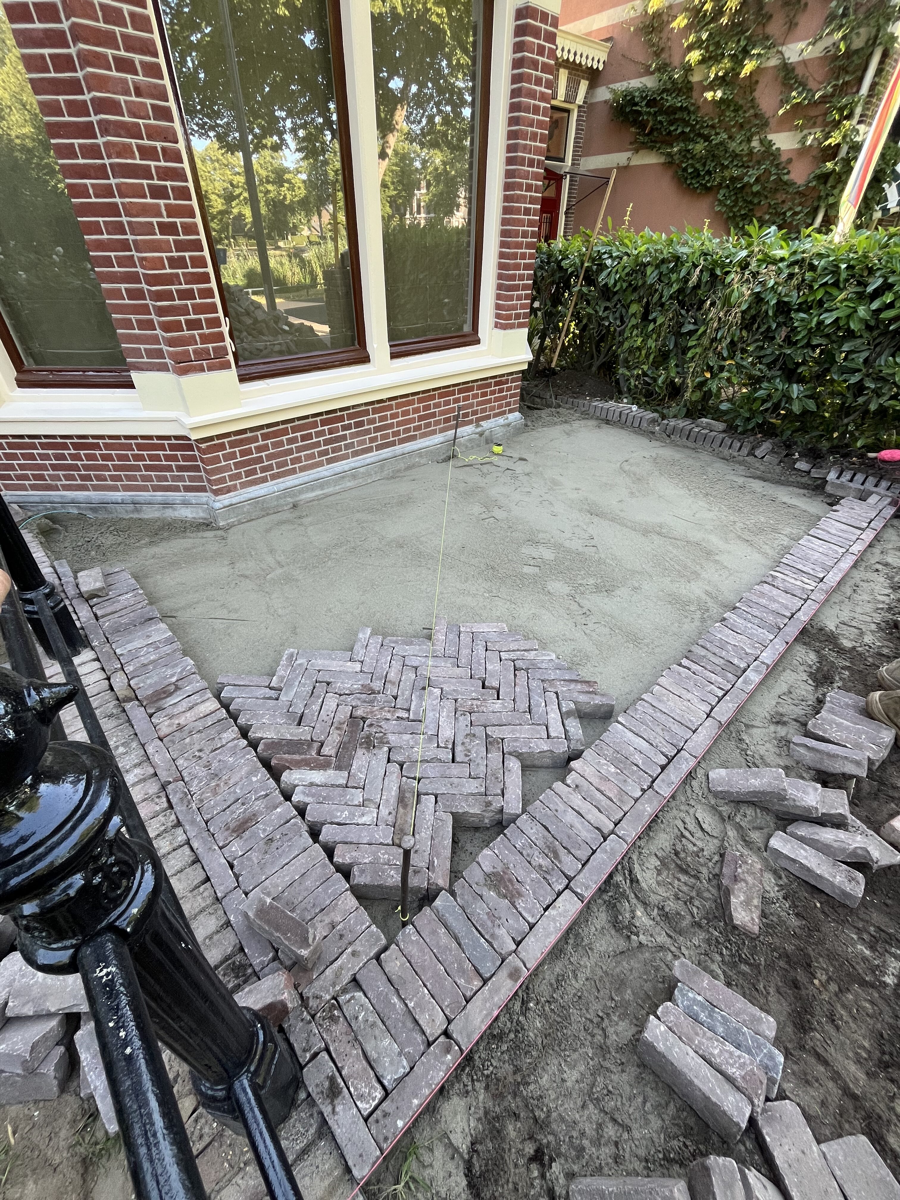 Stratenmaker aan het werk met klinkers en zandbed