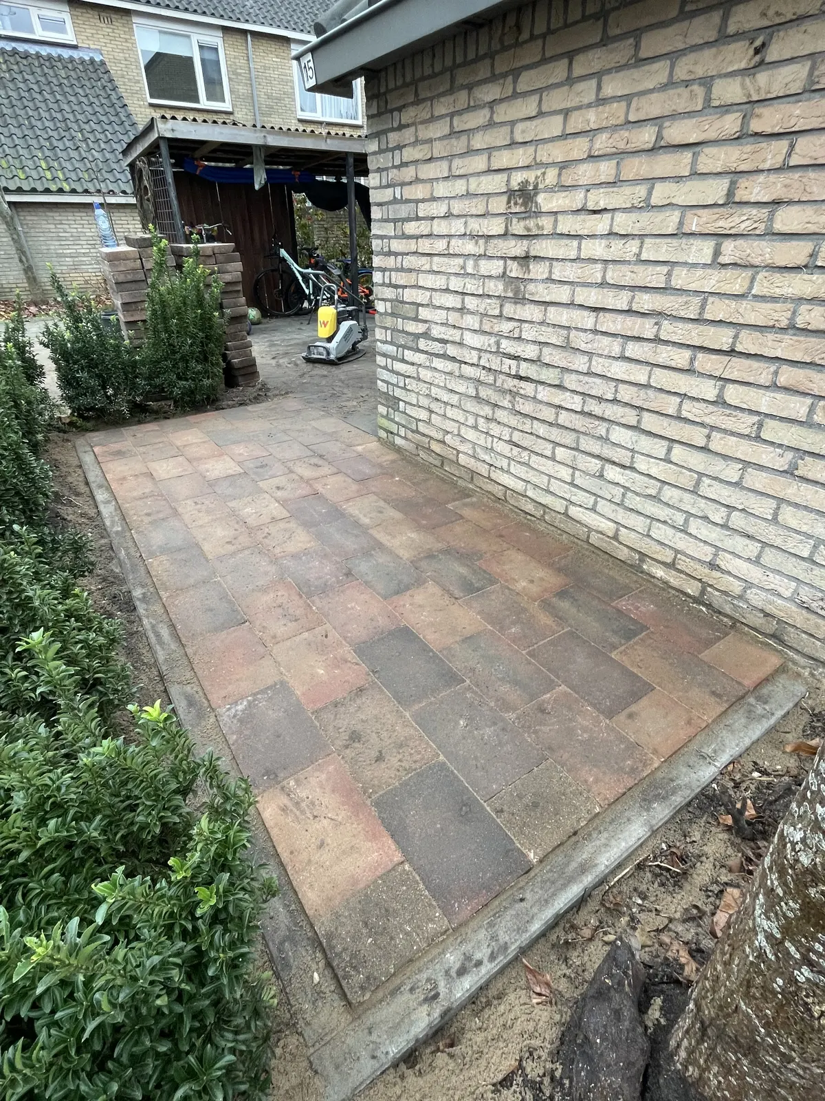 Pad naast woning met gemêleerde klinkers – hovenierswerk van Herfst Sierbestrating in Noordeinde